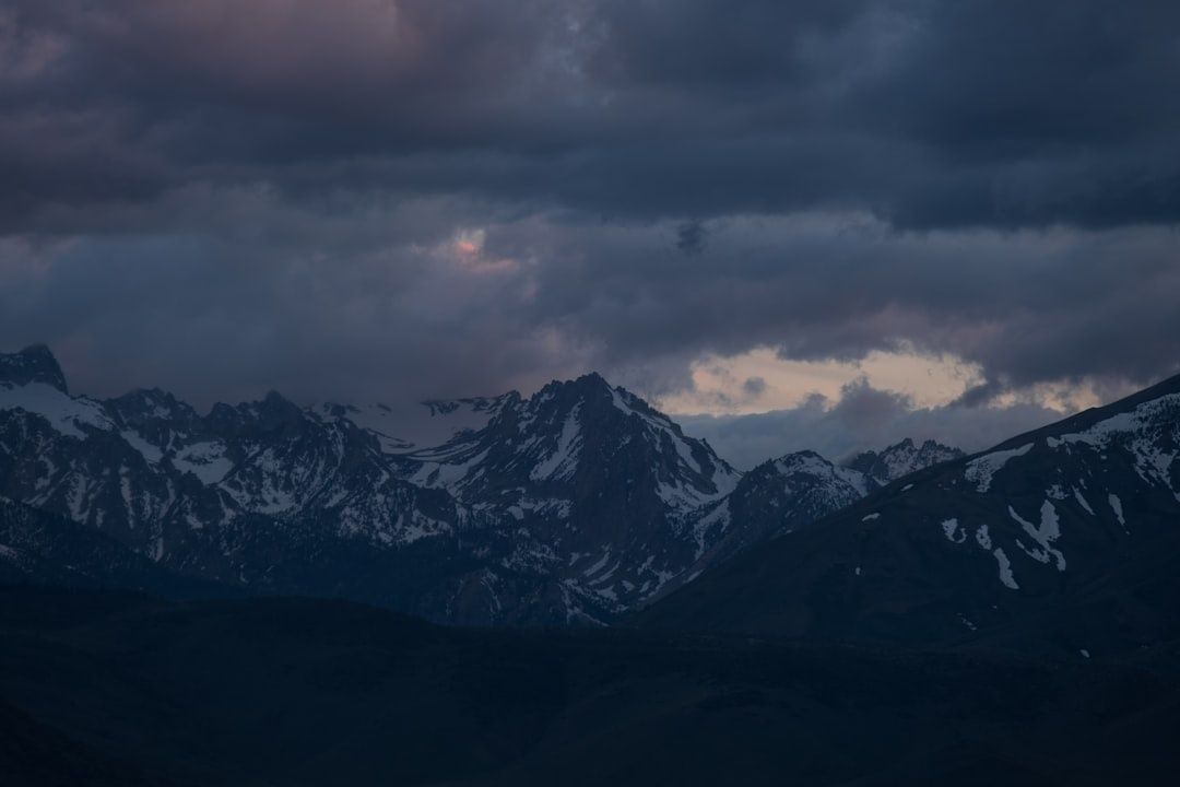 Mørke stormskyer over snødekte fjelltopper i høyfjellet
